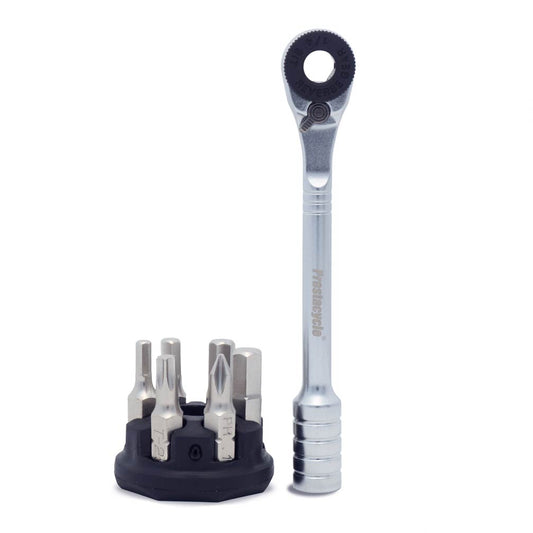The Prestaratchet Micro – Kit features a compact silver handle ratchet screwdriver standing upright beside a black round holder stand that contains six S2 multi-tool 1/4 bits in various shapes and sizes.