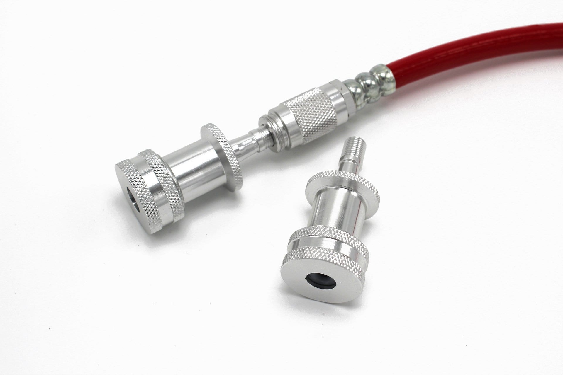 Two Prestacycle EZ-Grip Big Presta Head fittings, one on a red hose and one loose, are shown on a white surface. Both have knurled grips and threaded sections for secure connection to Presta valves or compatible equipment.