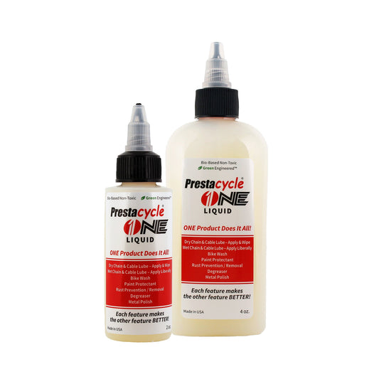 Two bottles of Prestacycle One Liquid, one small and one large, each with a pointed applicator cap and white label with red and black text describing their versatile uses for bike chains and cables.