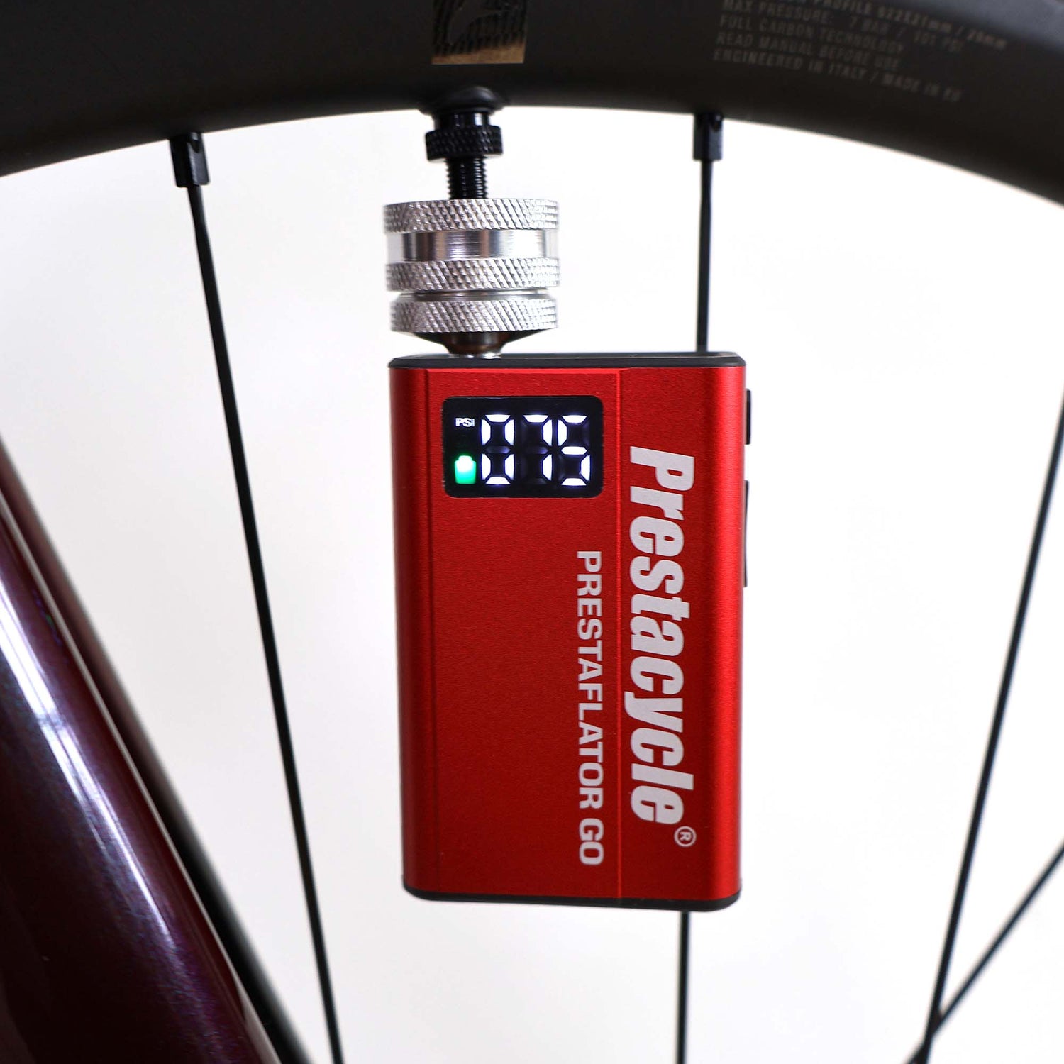 The Prestaflator GO - Portable Digital Rechargeable Preset Bicycle Tyre Inflator is shown attached to a bicycle wheel, with its screen displaying a precise tyre pressure of 19 PSI.