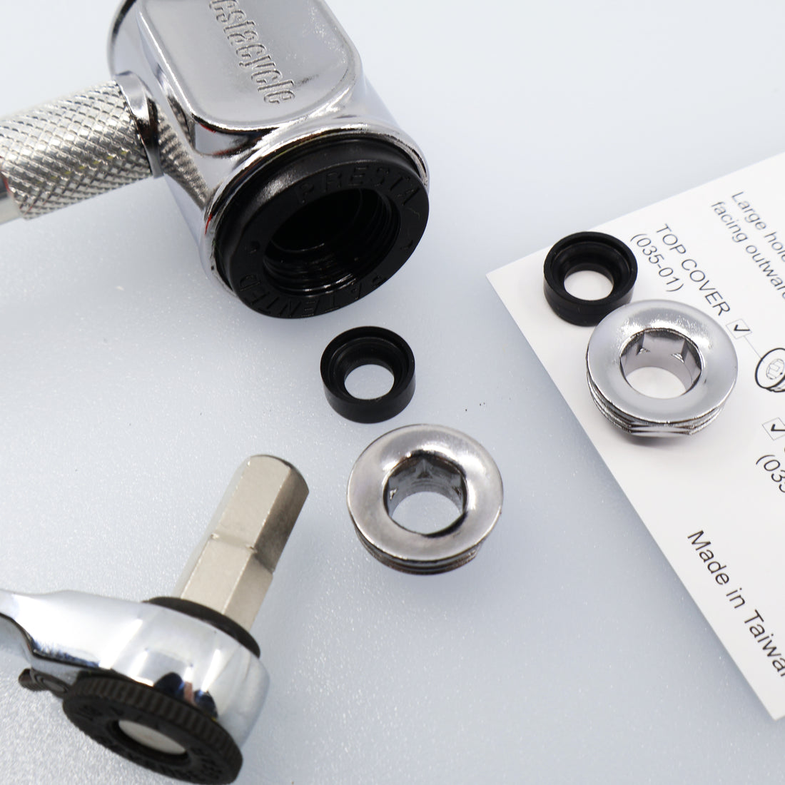 A close-up of a Prestaflator Pro Presta Head Rebuild Kit shows a ratchet tool, chrome washers, black rubber gaskets, and an instruction sheet neatly arranged for replacing pump head seals on a light surface.