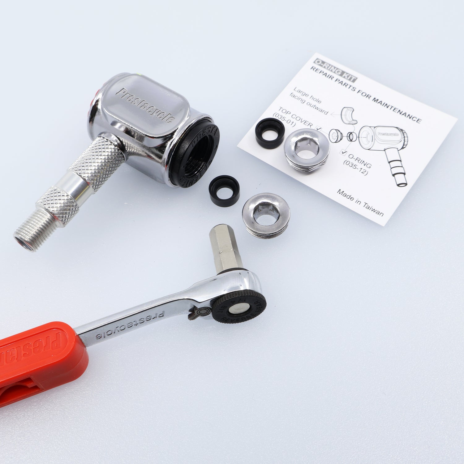 The Prestaflator Pro Presta Head Rebuild Kit, including a chrome ratchet tool with red handle, metal valve, washers, screws, Presta valve seal kit, and repair instruction sheet is displayed on a white background.