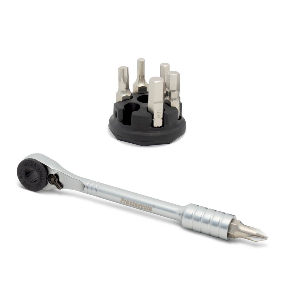 The Prestaratchet Micro Kit features a ratchet screwdriver with a metal handle, six interchangeable S2 bits, and a round black holder stand for versatile 1/4 bit storage.