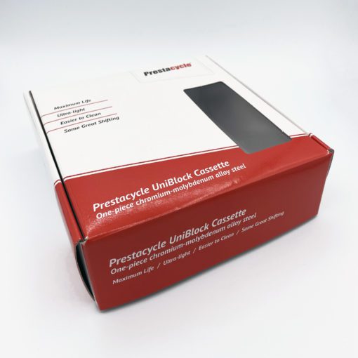 A white box with red accents displays the Prestacycle Uniblock PRO Gravel Cassette (11 Speed) for Shimano, highlighting Maximum Life and Ultralight features. A transparent window reveals part of the durable Chromoly Steel cassette.